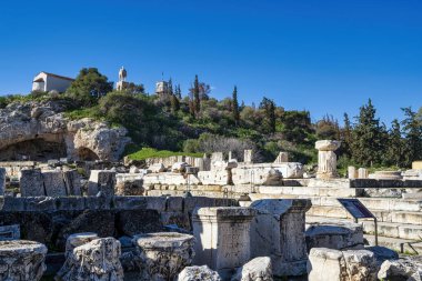 Ploutonion mağarası ve Eleusis 'teki Demeter tapınağı kalıntıları, antik sütunlar ve mavi gökyüzünün altında oyulmuş taşlar..