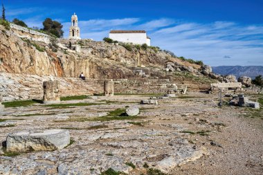 Eleusis, Yunanistan - 2 Şubat 2025: Eleusis 'teki Ploutonion mağarası sığınağı, yukarıda Panagia Kilisesi ve antik basamaklarda oturan bir turist ile yeraltı efsaneleriyle bağlantılı..