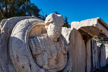 Eleusis 'te zırhlı bir Roma heykeli giyiyordu. Üzerinde, antik Yunan tapınağındaki imparatorluk varlığını sembolize eden detaylı bir kürk ve pelerin vardı..