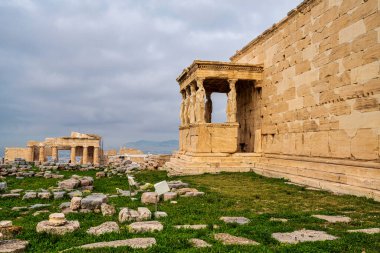 Erechtheion Tapınağı 'nın Süvari heykelleri Akropolis' te belirgin bir şekilde duruyor ve Propilaea geçidi uzaktan görülebiliyor..