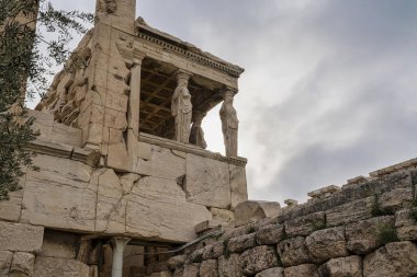 Erekteyon 'un Atina' daki Akropolis 'teki Caryatid Verandası' nın yukarıya bakan manzarası, antik taşlarla çerçevelenmiş ve gökyüzü tarafından aydınlatılmış.