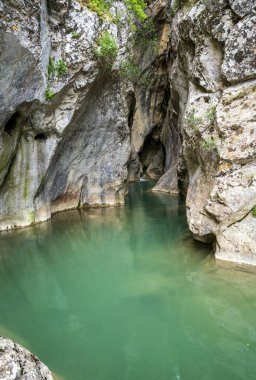 Sakin turkuaz su dar bir kireç taşı yuvasını dolduruyor, Yunanistan 'ın uzak Aziz Luke Geçidi' ndeki ışığı yansıtan pürüzsüz yontulmuş duvarları.