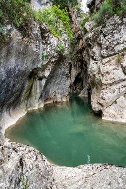 Sakin turkuaz su dar bir kireç taşı yuvasını dolduruyor, Yunanistan 'ın uzak Aziz Luke Geçidi' ndeki ışığı yansıtan pürüzsüz yontulmuş duvarları.