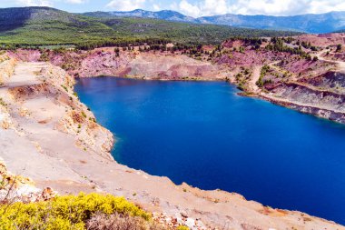 Yunanistan 'ın Evia kentindeki kayalık yamaçlar ve seyrek yeşilliklerle çevrili Triadas Gölü' ndeki turkuaz suların canlı bir görüntüsü.