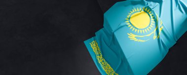 Kazakistan bayrağı. Kumaş desenli Kazakistan bayrağı koyu arkaplanda izole edilmiş. 3B illüstrasyon