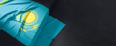 Kazakistan bayrağı. Kumaş desenli Kazakistan bayrağı koyu arkaplanda izole edilmiş. 3B illüstrasyon