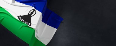 Lesotho bayrağı. Kumaş desenli Lesotho bayrağı koyu arkaplanda izole edilmiş. 3B illüstrasyon