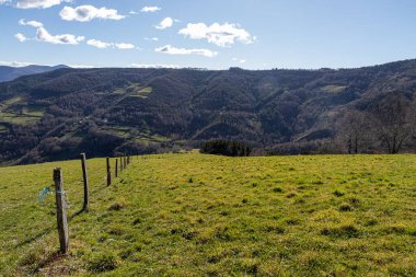 Ah Cebreiro, İspanya. O Cebreiro yakınlarındaki vadileri ve tepeleri çevreleyen bir kış günü, yapraksız ağaçlar ve kahverengi tonlarla dağınık bulutlar altında