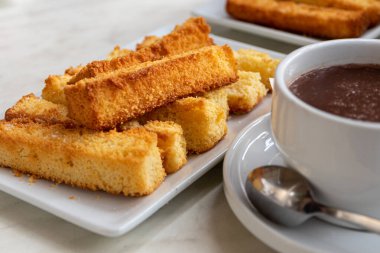 Cantabria, İspanya. Bir fincan sıcak çikolatayla eşleştirilmiş bir tabak churros sobaos pasigos, Pasiego vadilerinden geleneksel bir tatlı sergiliyor.