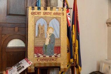 Cambridge, İngiltere. İşlemeli kilise afişi Meryem Ana 'nın kulesiyle Bakire ve Çocuk' u gösteriyor.