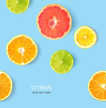 Limon, kireç, portakal ve greyfurttan yapılmış yaratıcı desen. Düz yatıyordu. Yemek konsepti. Limon, limon, portakal ve greyfurt mavi arka planda.