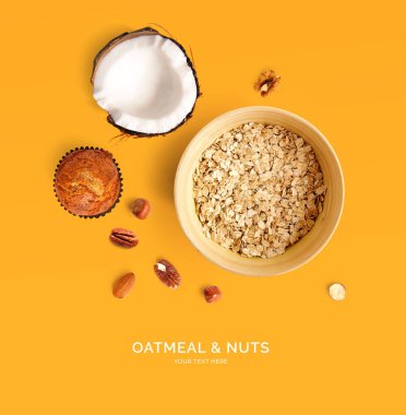 Sarı arka planda yulaf ezmesi ve fındıklardan oluşan yaratıcı bir düzen. Düz yatıyordu. Yiyecek konsepti. 