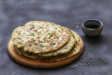 Homemade appetizing scallion pancakes served with soy sauce. Selective focus.
