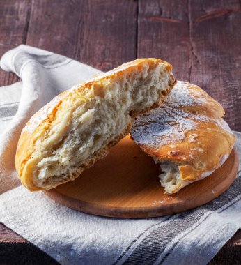 Ev yapımı ciabatta ekmeği ve ahşap zemin üzerinde tam tahıllı un. Kırsal biçim, seçici odak.