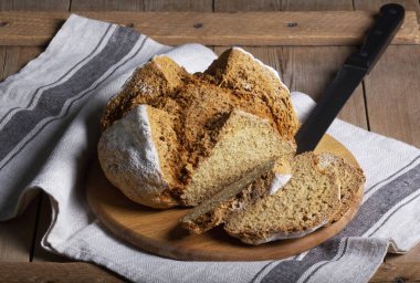 Geleneksel İrlanda sodası ekmeği tahıl ve çavdar unundan yapılmış ahşap bir masada. Kırsal biçim, seçici odak.