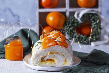 Mandalina ve yeşil bir kalple arkaplanında mascarpone, krema ve mandalina reçeli ile bezeli rulo. Sevgililer Günü için tatlı..