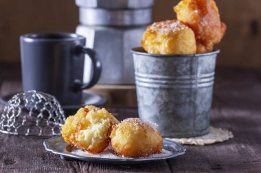 Sütlü çörekler, çay ve kahveyle servis edilen hafif ahşap arka plan. Kırsal biçim, seçici odak.