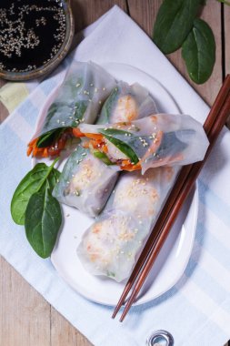 Yaz veya bahar ruloları karides, sebze ve ıspanakla, soya sosu ve susam ile servis edilir. Geleneksel Vietnam yemekleri. Kırsal biçim, seçici odak.