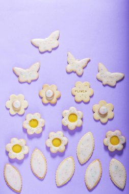 Limonlu kurabiyeler kelebek, çiçek ve yaprak şeklinde. Leylak arkaplan, bahar ya da yaz kompozisyonu üzerine jöleli ve renkli şekerle kaplanmış kurabiyeler..