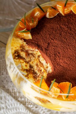 Mascarpone kremalı tiramisu tatlısı ve limonlu mandalina peyniri. Geleneksel İtalyan tatlısı kakao, mandalina dilimleri ve hafif arka planda biberiye ile süslenmiş..