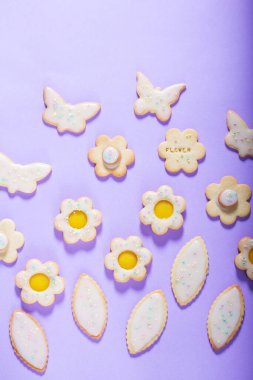 Limonlu kurabiyeler kelebek, çiçek ve yaprak şeklinde. Leylak arkaplan, bahar ya da yaz kompozisyonu üzerine jöleli ve renkli şekerle kaplanmış kurabiyeler..