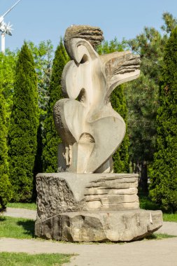 Chisinau 'daki Moldova Teknik Üniversitesi yakınlarındaki parkta beton heykel. Güneşli bir bahar gününde ağaçların arka planındaki heykel.
