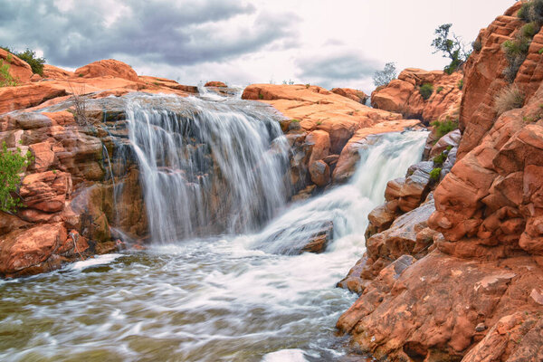 Gunlock Falls State Park Reservoir waterfall views, Utah by St George. 2023 record snowpack spring run off over desert erosion sandstone. Utah, USA.