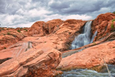Gunlock Falls State Park Rezervuar Şelalesi manzaralı, Utah, St. George 'dan. 2023 rekor kar yığınları çöl erozyon kumtaşının üzerinden geçiyor. Utah, ABD.