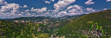 Umbria bölgesindeki Assisi ili, tepe kasaba manzarası, yazın kırsal alan. İtalya 2023.
