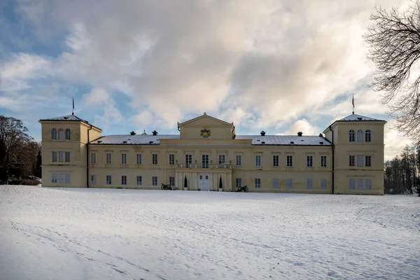 State Classicist chateau Kynzvart in winter under snow and with blue sky - castle is located near the famous west Bohemian spa town Marianske Lazne (Marienbad) - Czech Republic