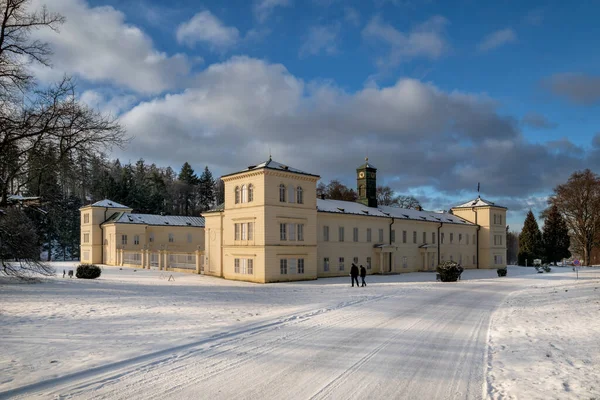 State Classicist chateau Kynzvart in winter under snow and with blue sky - castle is located near the famous west Bohemian spa town Marianske Lazne (Marienbad) - Czech Republic