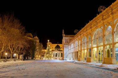 Çek spa kasabası Marianske Lazne 'de (Marienbad) kar yağışı - ana sütun ve Noel ağacıyla beyaz pavyon - Çek Cumhuriyeti