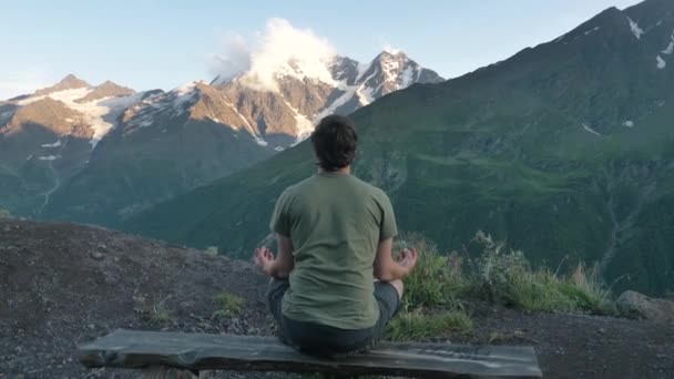 Man Sits Lotus Position Backdrop Mountains Sunset Meditates Rear View — Stockvideo