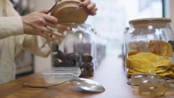 Woman Takes Dried Plums Out Glass Jar Put Plastic Box — Stockvideo
