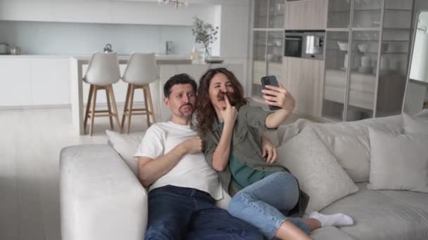 Couple Love Makes Funny Selfies Smartphone While Sitting Sofa Bright — Vídeo de stock