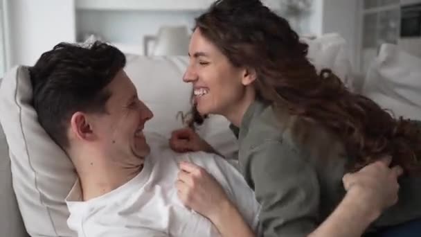 Happy Newlyweds Dark Hair Have Fun Tickling Hugging Lying Sofa — Wideo stockowe