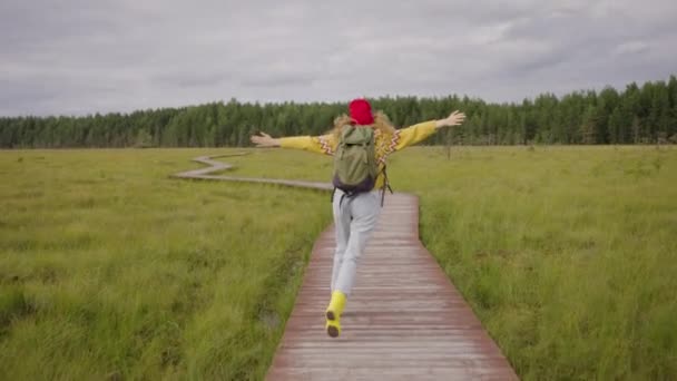 Happy Woman Backpack Runs Wooden Pathway Forest Spreading Hands Active — Stok video