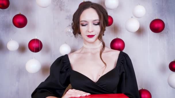 Young Woman Brunette Hairstyle Red Lipstick Black Dress Opens Christmas — Vídeo de Stock
