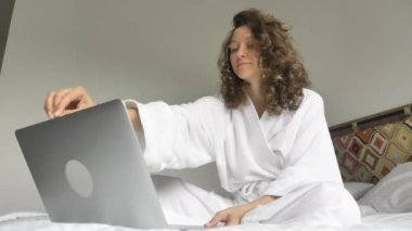 Sürpriz hissi, büyük kazanç ya da ödül. Beyaz önlüklü bir kadın dizüstü bilgisayarı açar ve haberi duyunca sevinir. Bir otel odasında ya da yatak odasında otururken bir mesaj.