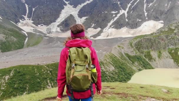 Pembe Ceketli Dağlarda Göl Manzaralı Yeşil Bir Sırt Çantasıyla Gezgin — Stok video