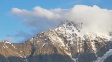 Elbrus bölgesinin yüksek dağlarının panoramik manzarası, günbatımında yedi buzul. Sihirli dağ manzarası yürüyüş, karlı kayalar, kamera hareketi