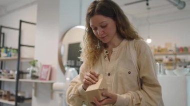 Dükkanda self-servis, bir kadın paket tatlı kutusunu açıyor, buzdolabının kapağını ambalaj konsepti sıfır atık olmadan bir eko-markette itiyor. Bilinci açık, güzel Avrupalı bir kadın yiyecek alır.