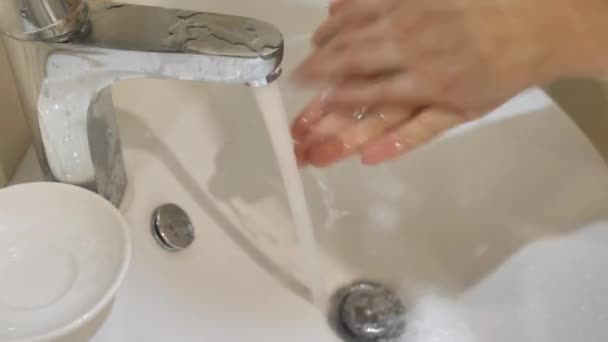 男人用水打开水龙头 彻底洗净 用一个白色的水槽把双手洗干净 冲洗掉泡沫 关掉水龙头 — 图库视频影像