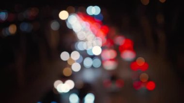 Şehirdeki trafik sıkışıklığında, kırmızı ve beyaz ışıklarda, yoldaki arabaların bulanık görüntüsü. Şehir manzarası bulanık