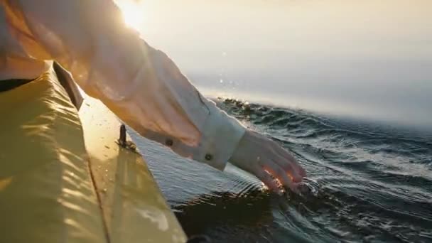 夏天黄昏时分 当小舟在船上航行时 曼斯的手掌和手指用手摸着水面 — 图库视频影像