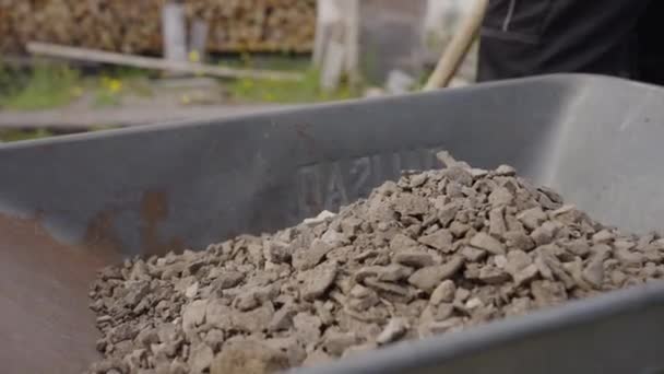 园丁在花园里干活 用铲子把碎石堆在铁车里 把体力劳动堆在地上 — 图库视频影像