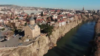 Güneşli bir günde, Tiflis ve eski şehrin merkezindeki Kura Nehri 'nin dik kıyısındaki eski bir Hristiyan tapınağının havadan görünüşü. Gürcistan 'da seyahat ve eğlence