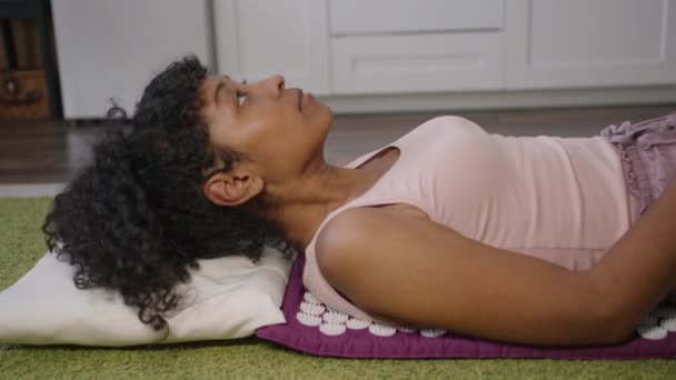Афроамериканська Жінка Лежить Масажному Килимку Вдома Підлозі Лікуванні Запобіганні Остеохондросу — стокове відео