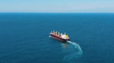 Petrol ürünleriyle dolu büyük bir gemi güneşli bir günde, hava manzaralı denizde yelken açar. Turkuaz bir denizin ya da okyanusun ortasındaki dev bir geminin genel görüntüsü. Uluslararası taşımacılık ve ticaret.