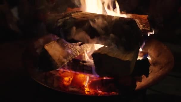 火柴堆在靠近火堆的地方燃烧 火堆周围的人都在温暖他们的手 烟升起 火苗熊熊燃烧 — 图库视频影像